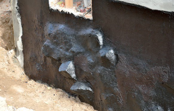 Widok ściany fundamentowej o silnie profilowanej powierzchni – wmurowane kamienie granitowe o znacznych rozmiarach.